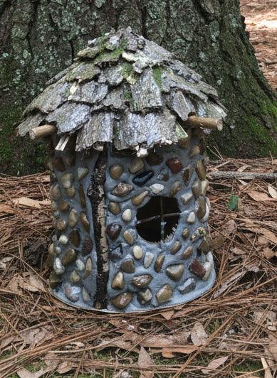 Decorative fairy house with stone mosaic design on a tree branch