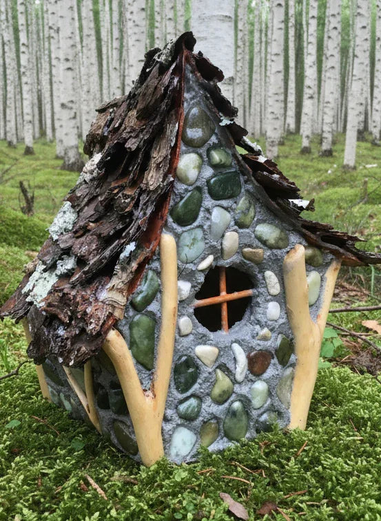 Handmade fairy house made from stones and wood in a forest setting
